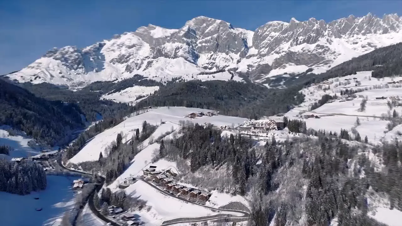 Der Hochkönig im Schnee unter blauem Himmel, darunter verschneite Hänge und Wald